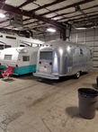 Picture of two trailer RVs in the shop
