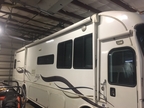 long RV with awning in shop